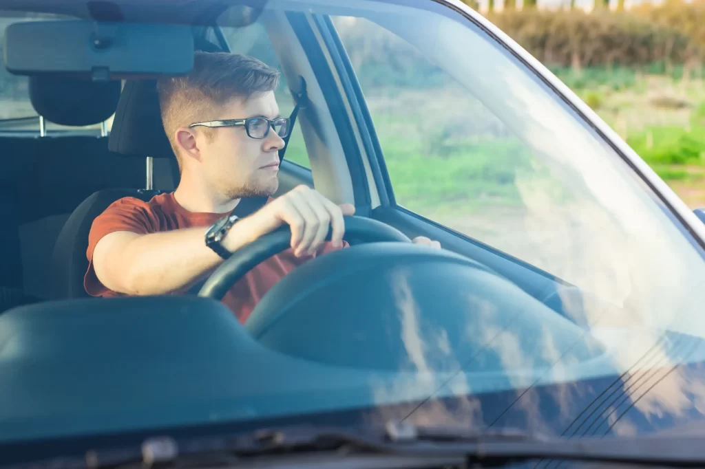 Driver assessing surroundings while locked out of their car.