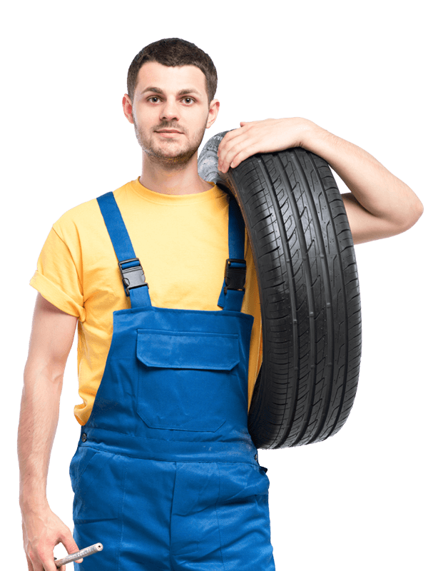 A mechanic holding a tire on one hand and the other a wrench.