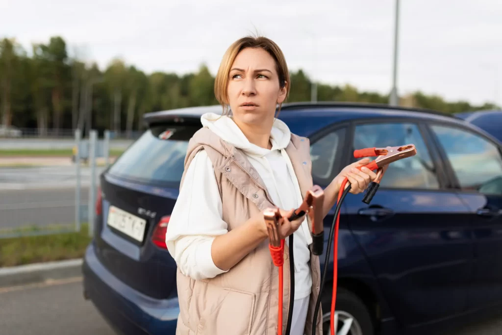 A girl stranded looking for help to jumpstart her car battery.