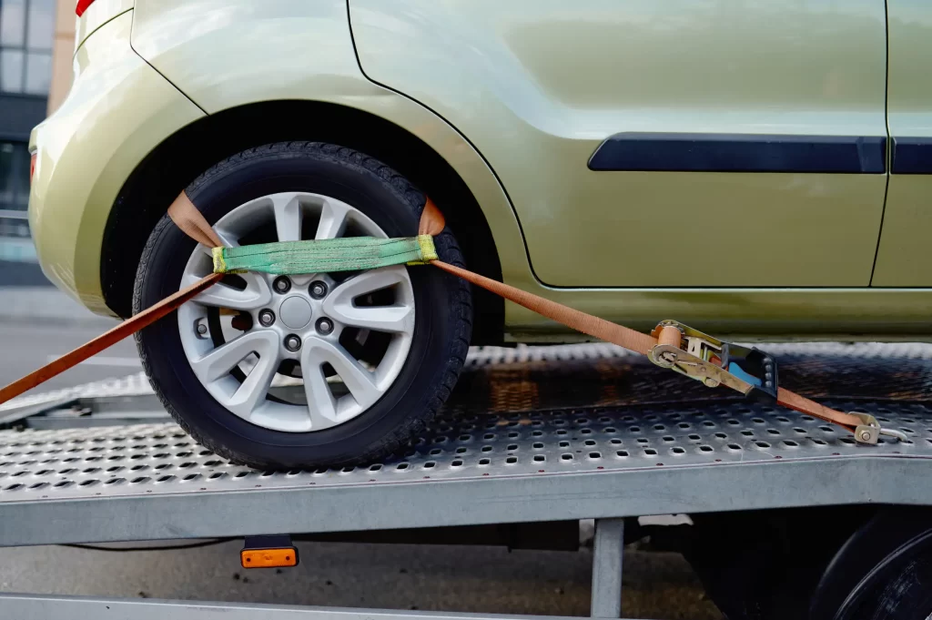 The wheel of a car being fastened and ready to drag by the winch out cables.