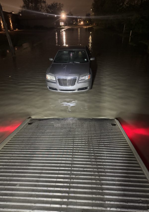 A car ready to load on the tow truck for a rescue on a flooded street.