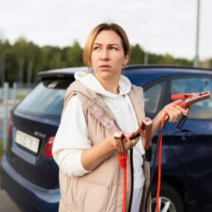 A girl stranded looking for help to jumpstart her car battery.
